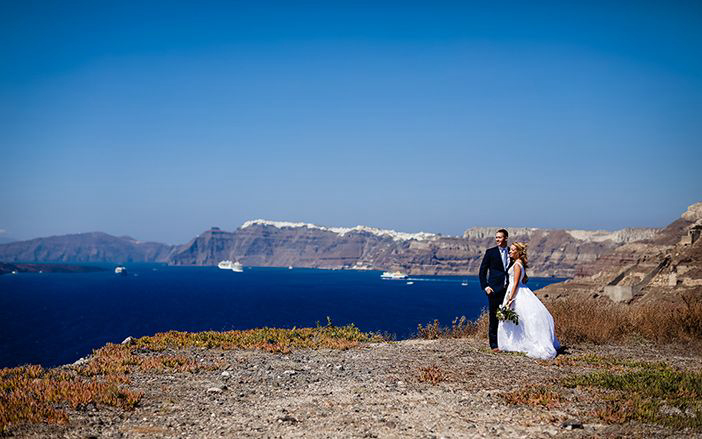 Νύφη και γαμπρός με θέα το νησί της Σαντορίνης